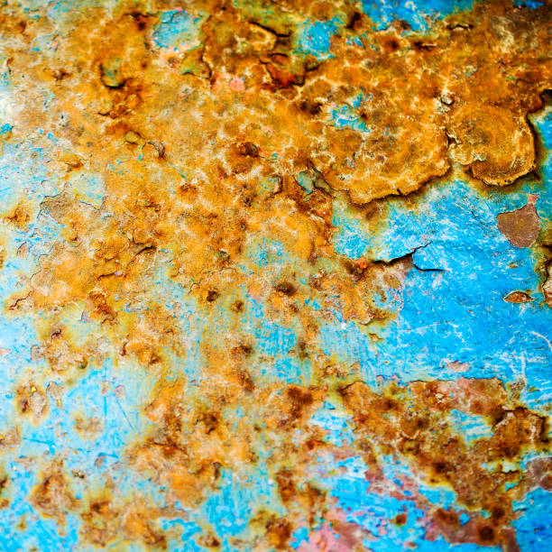 istock Rusted and corroded scratches and cracks on metal  background. Surface with a blue layers shabby old paint. Square. 941496108