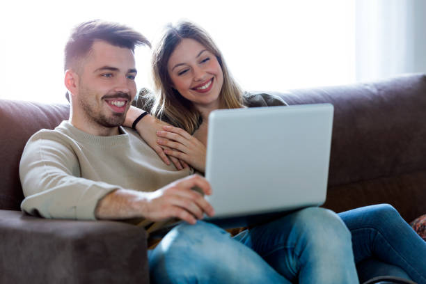istock Beautiful young smiling couple using their laptop at home. 941501424
