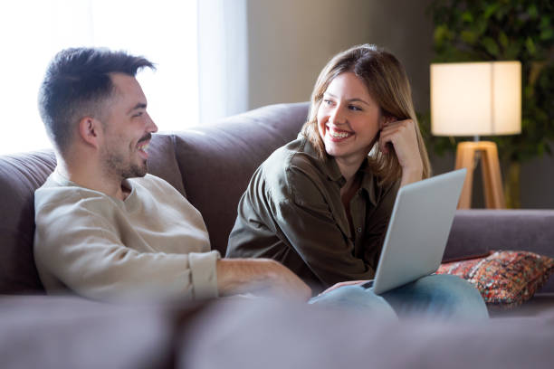 istock Beautiful young smiling couple using their laptop at home. 941504164