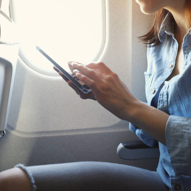 istock Unrecognizable woman uses smart phone on airplane 941504574