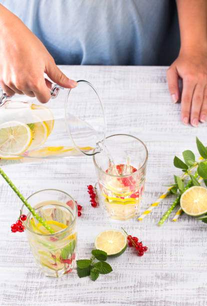 istock Beautiful young woman with lemonade in kitchen 941504592
