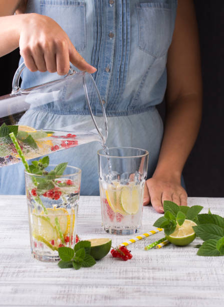 istock Beautiful young woman with lemonade in kitchen 941504600