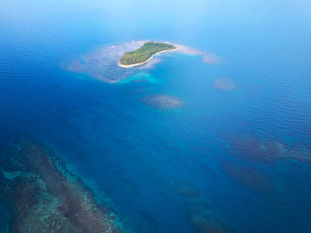 istock Small island in blue sea water 941505152