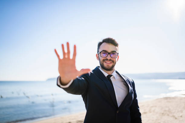 istock Company executive near the sea extending his arm 941508544