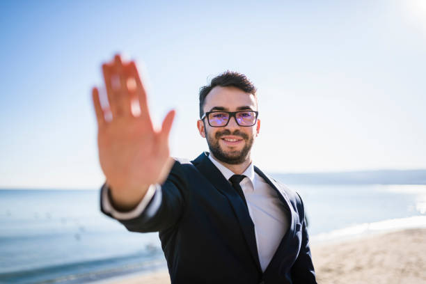istock Businessman by the sea making stop gesture 941508568