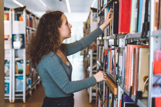 istock A young woman searching for a book in the library 941511046