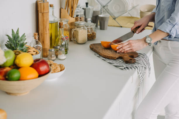 istock cropped image of girl cutting grapefruit at kitchen 941511610