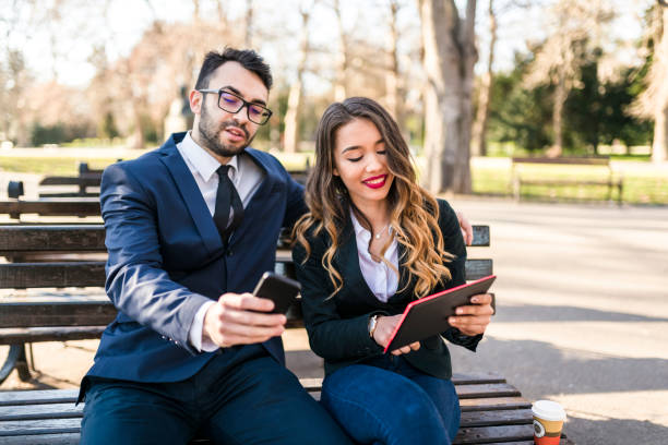 istock Business couple controlling smart office from the park 941511976
