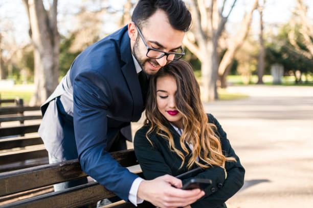 istock Young business executives flirting in the park 941512500