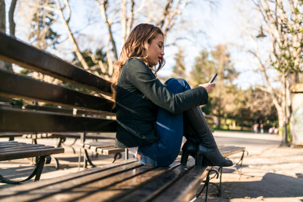 istock Lonely lady using her mobile phone in the park 941512650