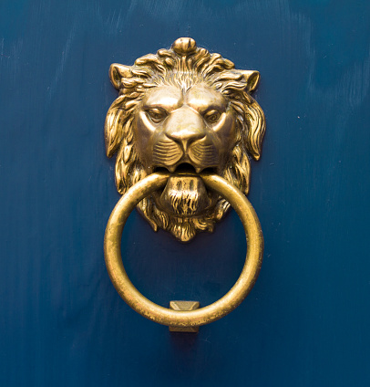 gold lion antique door knob on blue door