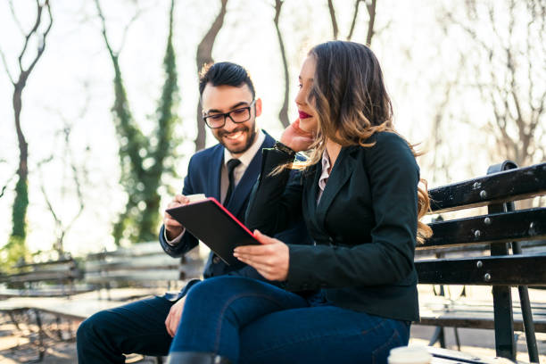 istock Smiling team mates with their tablet on the bench 941513252