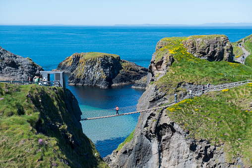 People cross the famous Carrick-A-Rede Rope Bridge in County Antrim, Northern Ireland