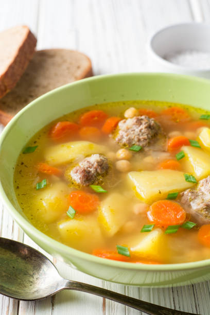 istock Soup with meatballs, vegetables and chickpea on white wooden table 941514980