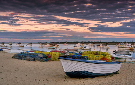 Beautiful sunset sky over fishing boats on the beach in Punta Umbria, Huelva, Spain.