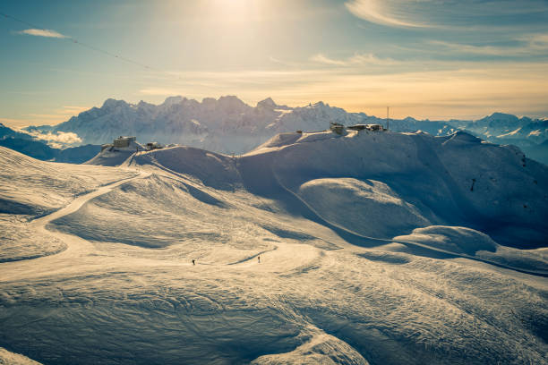 Sunset over Mont Blanc and the Chamonix range, seen from the top of the Verbier ski area in the Swiss alps. The pistes are empty and the chairlifts have stopped running.