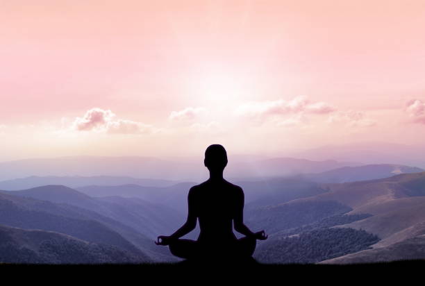 istock Yoga silhouette on the mountain in sunrays 941518694