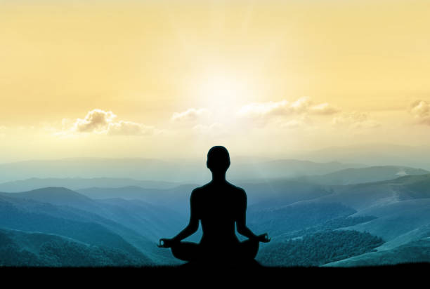 istock Yoga silhouette on the mountain in sunrays 941518736