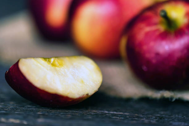 istock Whole and cut red apples on burlap napkin close 941523500