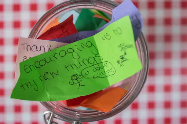 Thank-you jar stuffed with messages of appreciation of love and care, including one of appreciation for encouraging family to try new things (such as new foods).  Belfast, Northern Ireland.