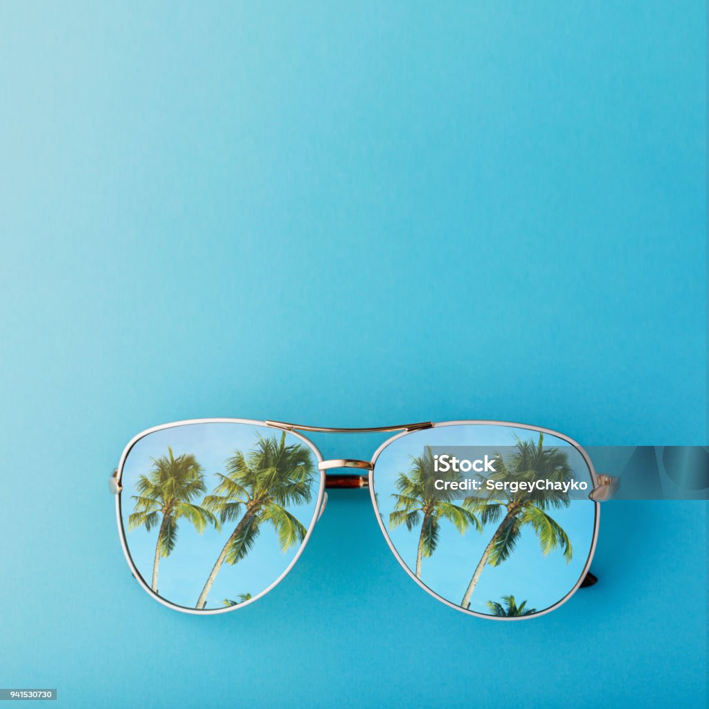 Sunglasses with palm trees reflected in them and space for text, top view Summer Stock Photo