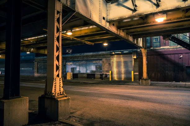 dunkle und unheimliche chicago städtische straße nachtlandschaft mit erhöhten cta trainieren spuren, vintage industrielle lagerhäuser und fabriken. - gasse stock-fotos und bilder