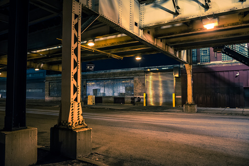 Oscuro y misterioso Chicago ciudad urbana calle paisaje nocturno con CTA elevado tren pistas, vintage naves industriales y fábricas. photo