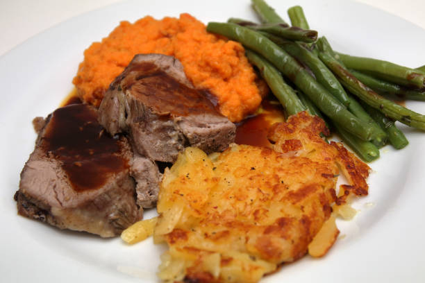 istock gigot with swiss hash browns, mashed carrots and beans 941532404