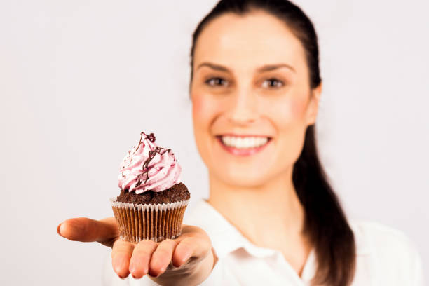istock woman presenting sweet cupcake 941532424