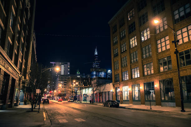 cena de rua noturna de cidade de chicago no west loop com o horizonte e arranha-céus sears willis tower ao fundo - factory night skyline sky - fotografias e filmes do acervo