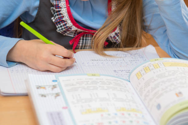 istock A pupil in class writing in a notebook, close-up 941535508