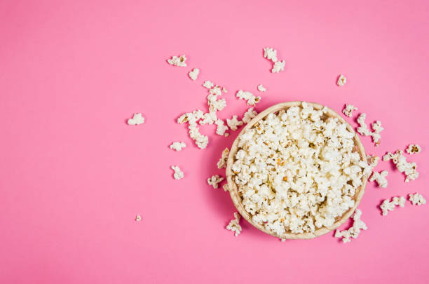попкорн чаша на розовом фоне вид сверху с копией пространства - popcorn snack bowl corn стоковые фото и изображения