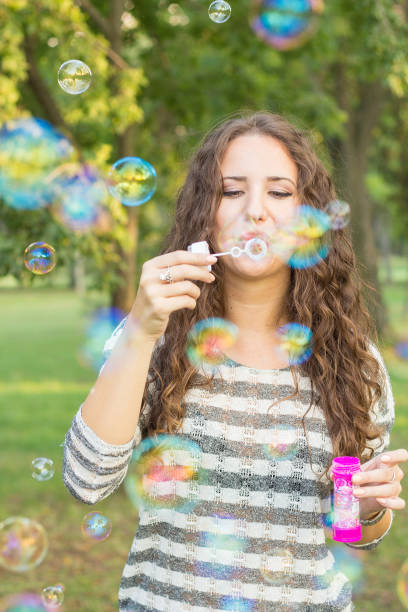 istock Girl in the park blowing bubbles 941542568
