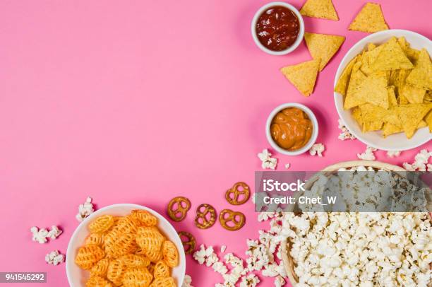 Popcorn And Chips In Bowl On Pink Background Top View Stock Photo - Download Image Now