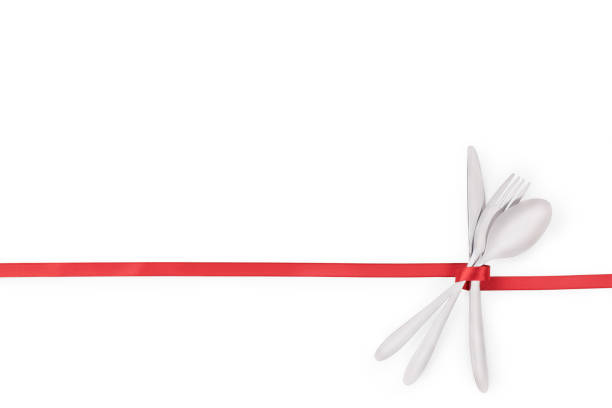 istock Fork, spoon and knife tied with a red ribbon isolated with copy space 941545870