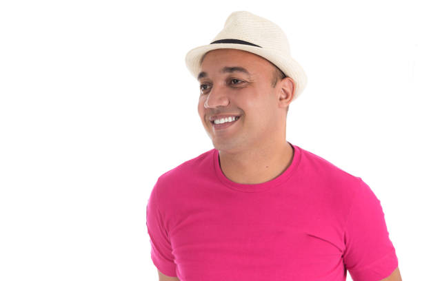 Portrait of a young smiling beautiful guy in a hat and shirt who looks at the camera