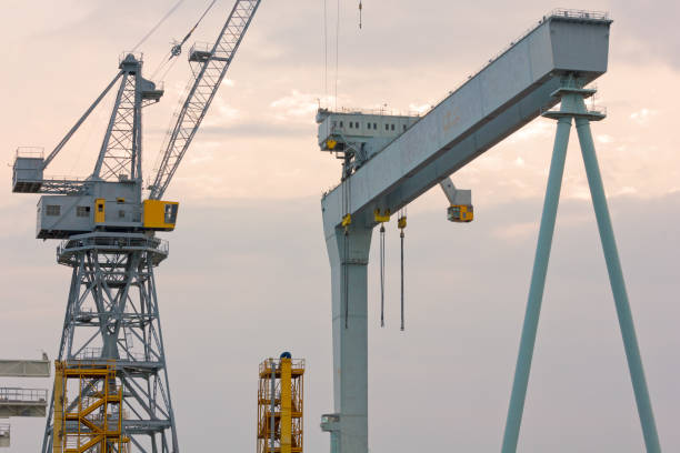 deux grues dans un chantier naval - construction built structure building activity shipyard photos et images de collection