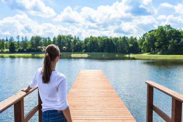 istock Woman relaxes on a lake pier 941562902