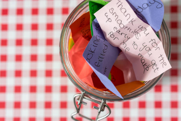 Lovely home jars with red ribbons and heart-shaped pendants on placemat