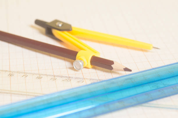 istock Yellow Drawing compass with black pensil  and rulers on graph paper. 941567250