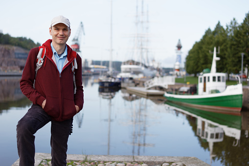 Tourist with backpack standing on waterfront in Turku, Finland