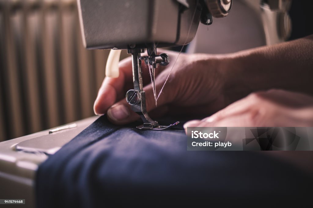 Donna che lavora su una macchina da cucire - Foto stock royalty-free di Cucire