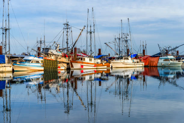 istock Fishing boats on the dock and their reflection 941575238
