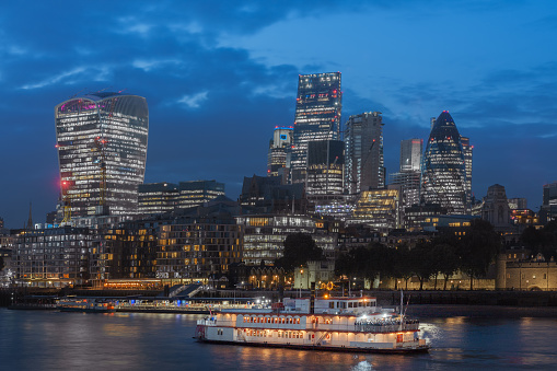 Thames embankment and london skyscrapers in City of London in the night.