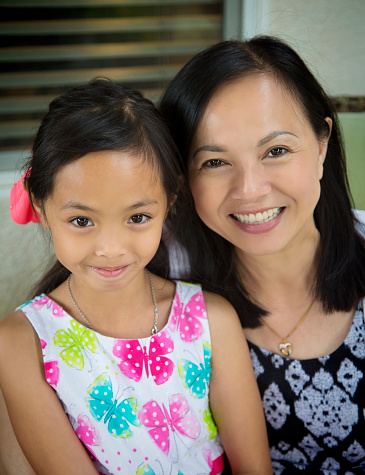 Vietnamese mother and daughter smile at camera