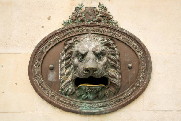 Lion-shaped bronze postboxes in the historic city center of Novelda, Spain. 'Otros Destinos' means other destinations