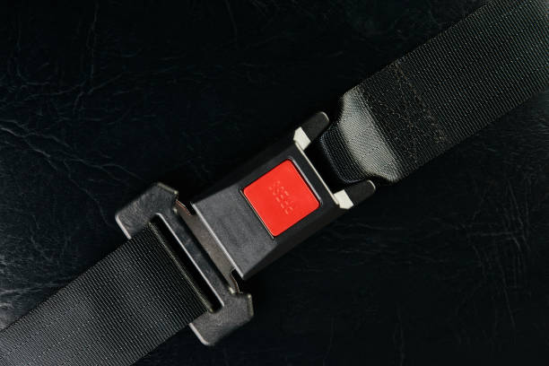 istock Fastened seat belt on black leather background, close-up. Safety 941587598