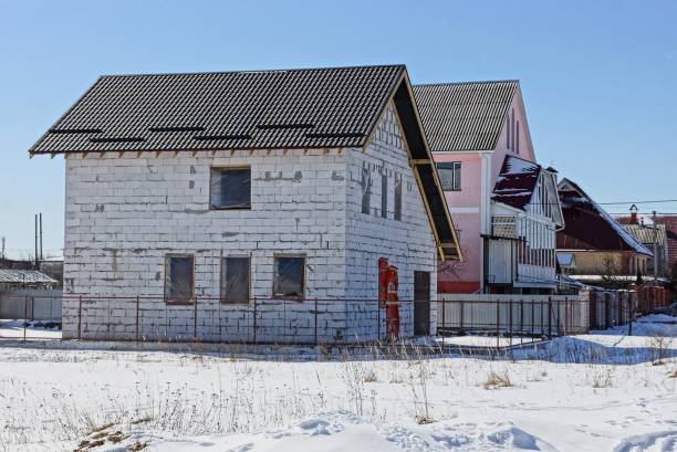white unfinished brick house on a building site in the snow