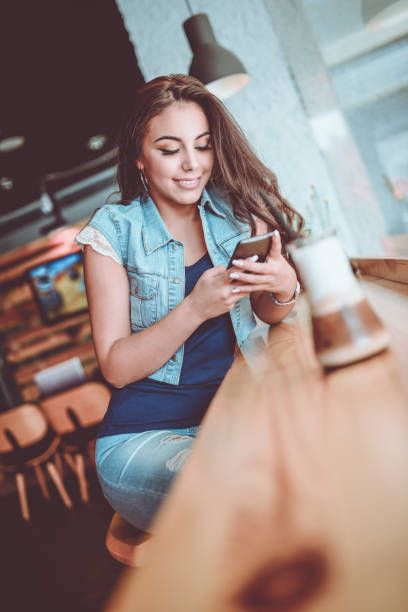 istock Young Female Using Smartphone at her Favorite Coffee Shop 941590868