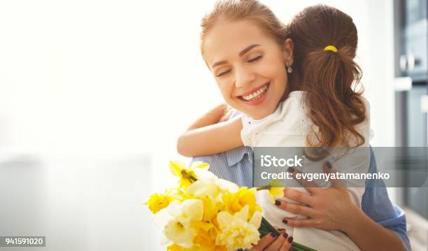 Happy Mothers Day Child Daughter Gives Mother A Bouquet Of Flowers To Narcissus And Gift Stock Photo - Download Image Now